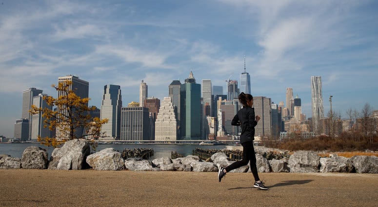 A jogger runs along the Brooklyn Bridge Park, February 8, 2017 in the Brooklyn borough of New York City. Warm Winter New York Weather