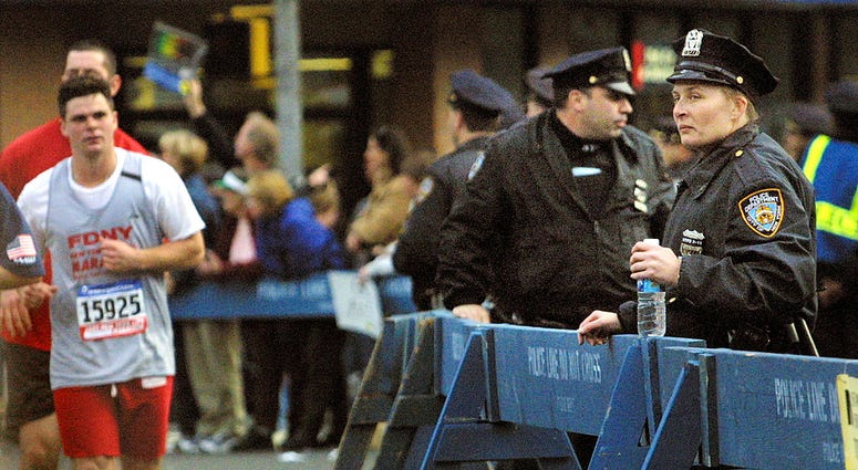 New York City police officers watch runners pass through Manhattan November 4, 2001 during the 32nd New York City Marathon. NYPD Marathon