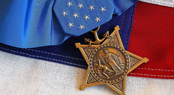The Medal of Honor rests on a flag beside a SEAL trident during preparations for an award ceremony for Lt. Michael P. Murphy October 2, 2007 in Washington DC. Medal of Honor
