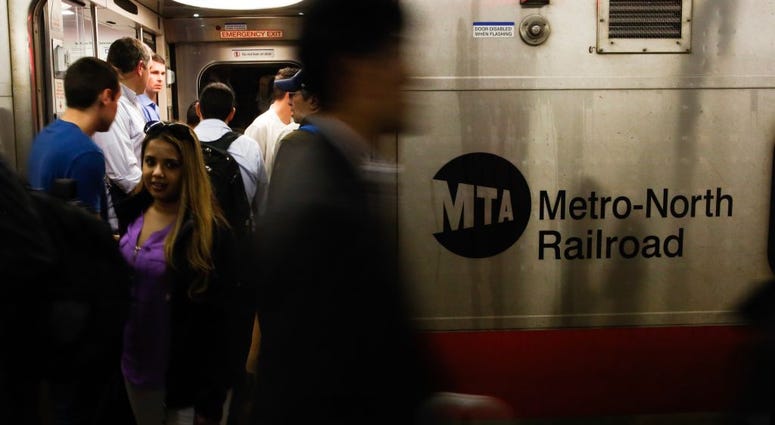 Commuters board a train as they wait for service to be restored after a severe thunderstorm downed trees that caused power outages resulting in several Metro-North lines being suspended at Grand Central Terminal on May 15, 2018 Metro-North