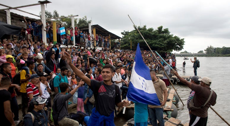 Hundreds of Honduran migrants stand at the shore of the Suchiate river on the border between Guatemala and Mexico, in Tecun Uman, Guatemala, Thursday, Oct. 18, 2018. Guatemala Caravan