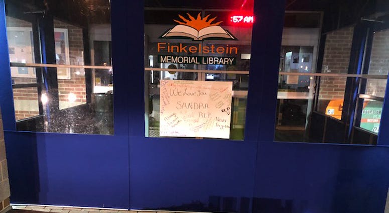 A makeshift memorial grows outside Finkelstein Library in memory of a security guard who was stabbed to death while on duty. Finkelstein Library