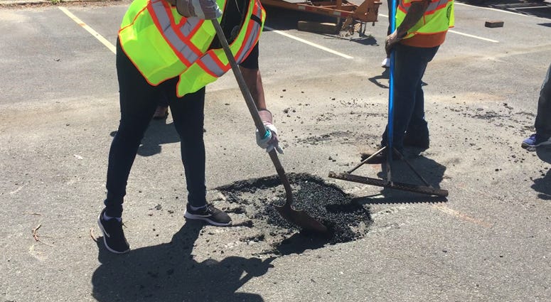 Workers repair a pothole in Suffolk County