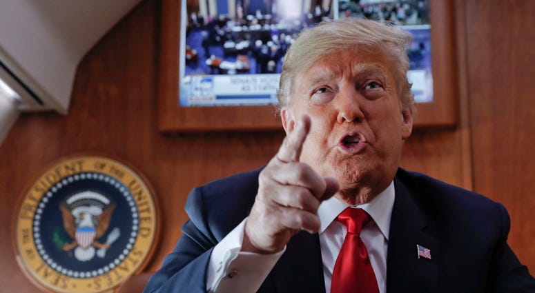 President Donald Trump, on board Air Force One, gestures while speaking to members of the travel press after watching a live television broadcast of the Senate confirmation vote of Supreme Court nominee Brett Kavanaugh, Saturday, Oct. 6, 2018. President Donald Trump