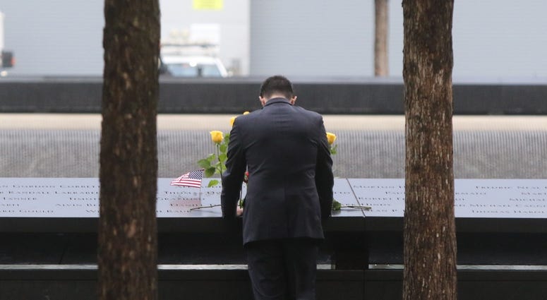 A man looks at names etched into granite, parts of the memorial pool for the North Tower prior to the ceremonies