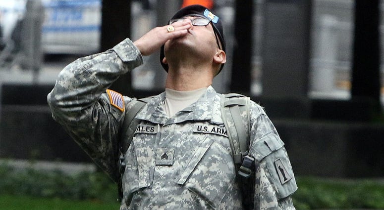 Army Sgt. Edwin Morales of the Bronx kisses up to the sky as part of honoring his cousin, Ruben Correa