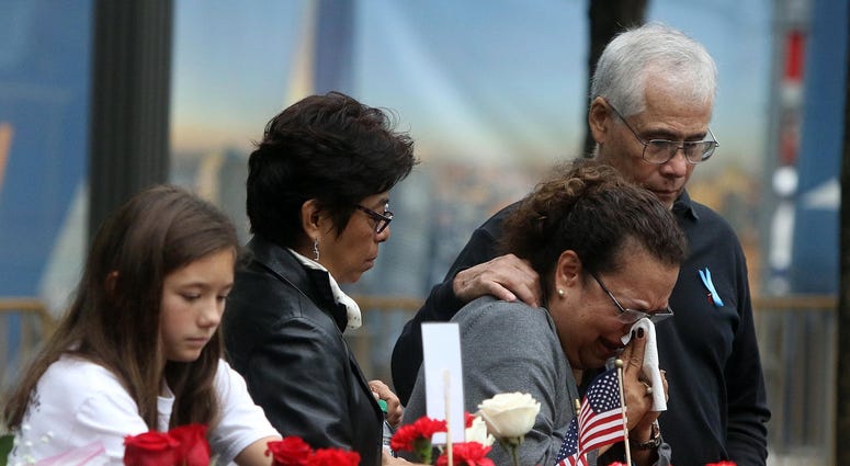 A woman is overcome with emotion at the North Tower Memorial during ceremonies at the National September 11 Memorial observing the 17th anniversary of the attacks that killed people in Manhattan