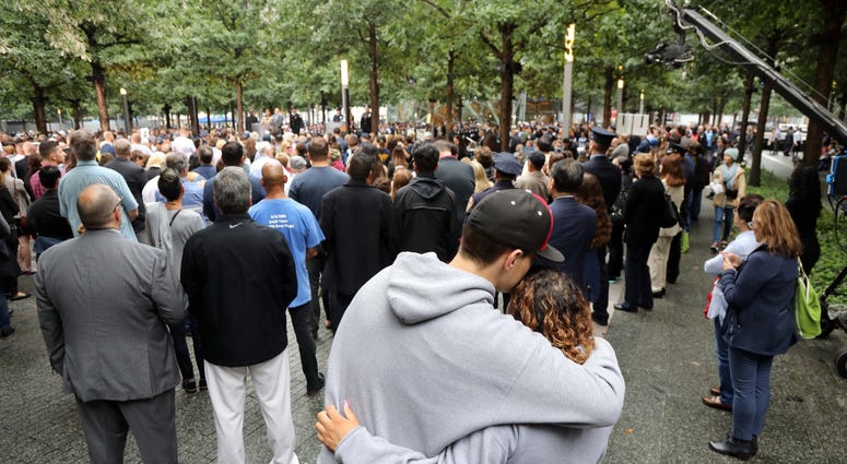 A couple hug as they listen to the names of those who perished on 9/11.