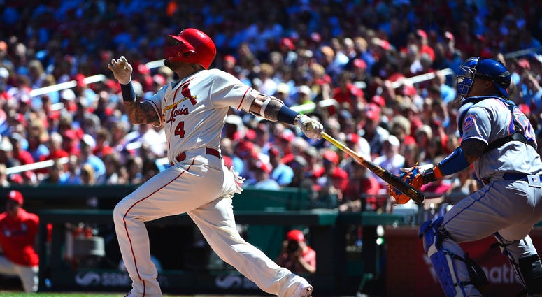 St. Louis Cardinals catcher Yadier Molina (4) hits a sacrifice RBI against the New York Mets during the third inning at Busch Stadium. Mets Cardinals