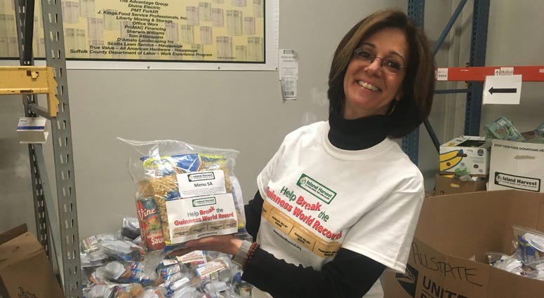 An Island Harvest volunteer holds a food package as part of their goal to break a world record. Island Harvest Record