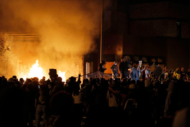 Protesters gather in front of the burning Minneapolis police 3rd Precinct building Thursday, May 28, 2020, in Minneapolis. Minneapolis