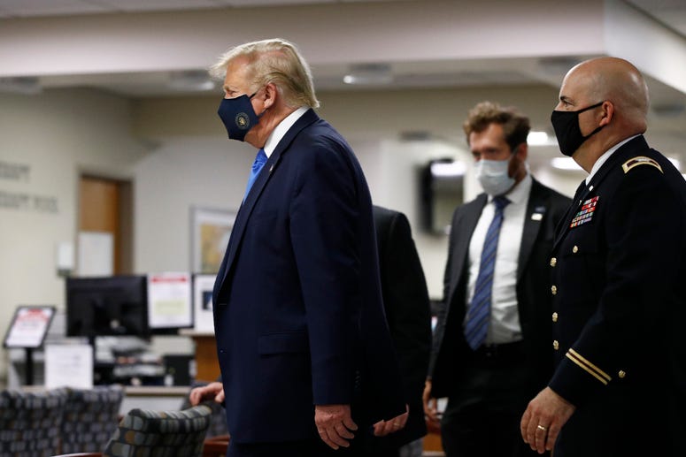 President Donald Trump wears a face mask as he walks down a hallway during a visit to Walter Reed National Military Medical Center in Bethesda, Md., Saturday, July 11, 2020. Trump mask