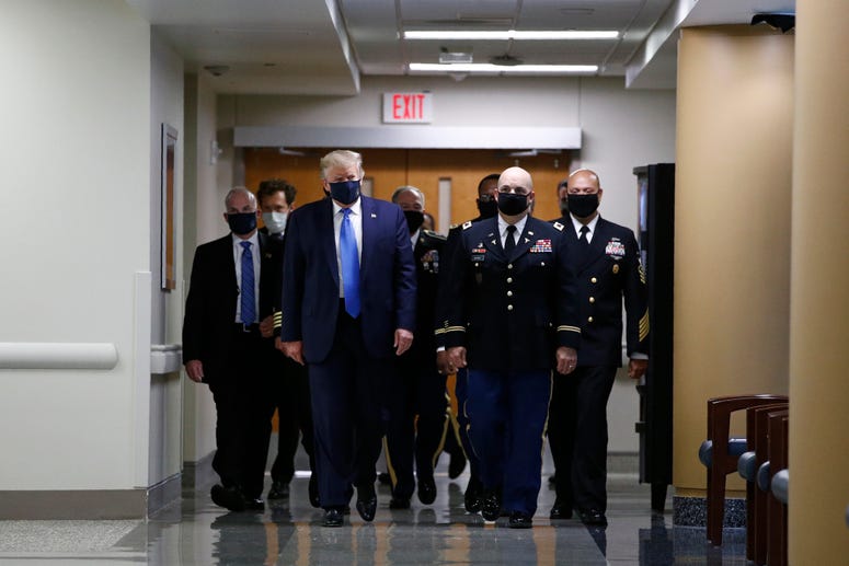 President Donald Trump wears a face mask as he walks down a hallway during a visit to Walter Reed National Military Medical Center in Bethesda, Md., Saturday, July 11, 2020. Trump mask