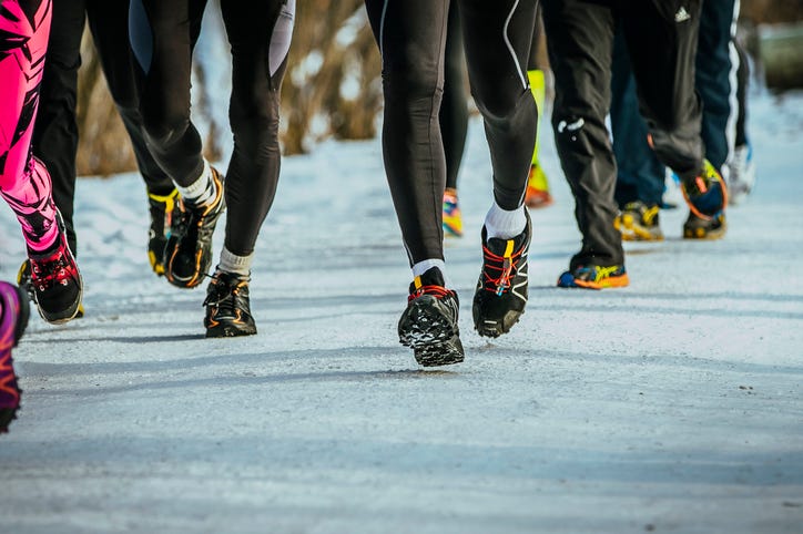 Group of runners on winter trail in snow Winter Marathon
