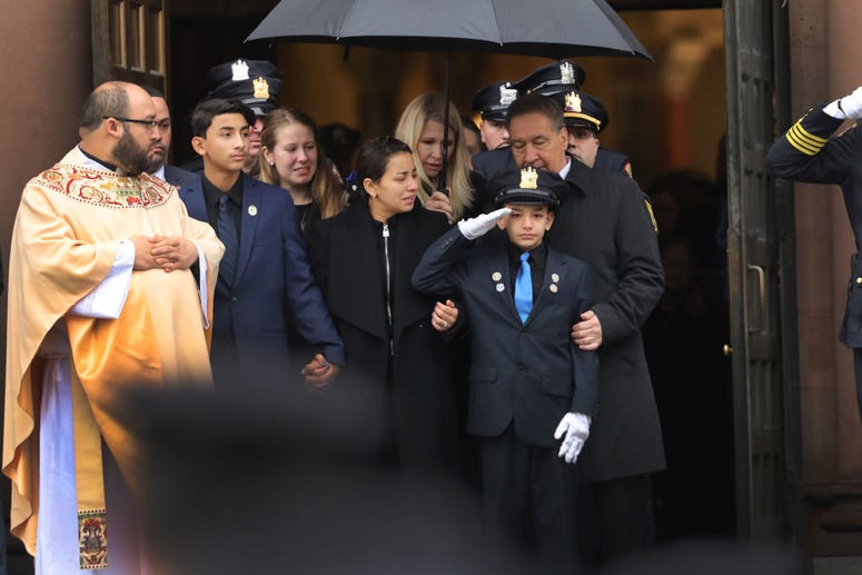 Family members watch as the casket for New Jersey Detective Joseph Seals is brought out of a church during his funeral on December 17, 2019 in Jersey City, New Jersey. Detective Joseph Seals funeral