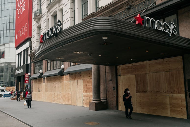 Pedestrians walk by the Macy's flagship store after workers cleaned and boarded up damage sustained during a night of violent protests and looting in Midtown, Manhattan on June 2, 2020 in New York City. Macy's After Looting