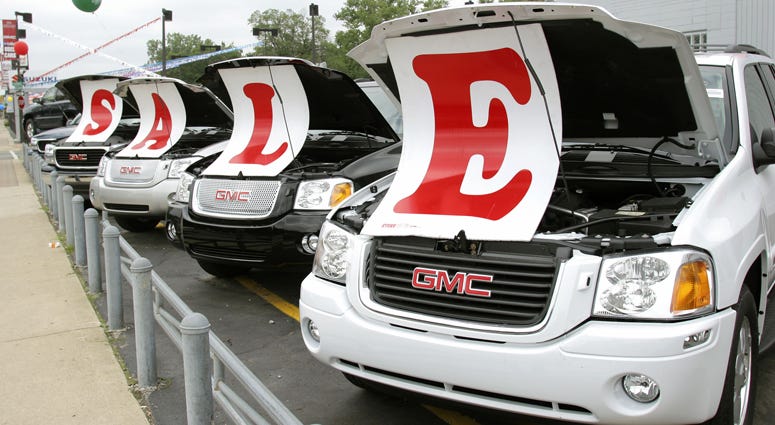 Sale signs lie on vehicles at a General Motors Chevrolet dealership July 6, 2005 in Ferndale, Michigan. Car dealership