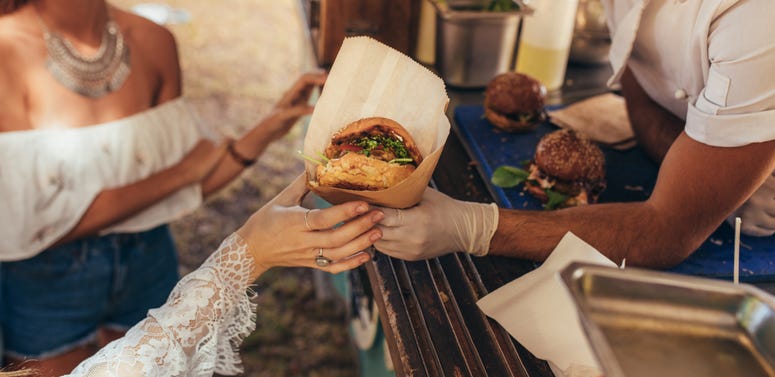 Woman reaching for a burger at food truck. Food Truck