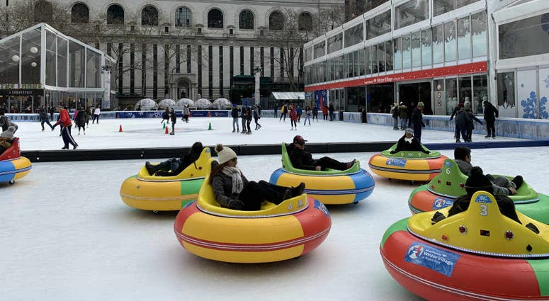 People ride bumper cars on the ice during the cold weather at Bryant Park ice bumper cars.jpg