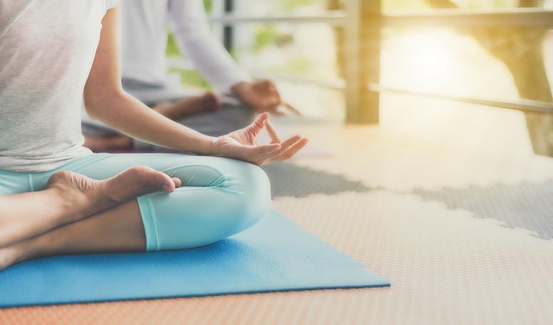 A group performs yoga outdoors. Outdoor yoga