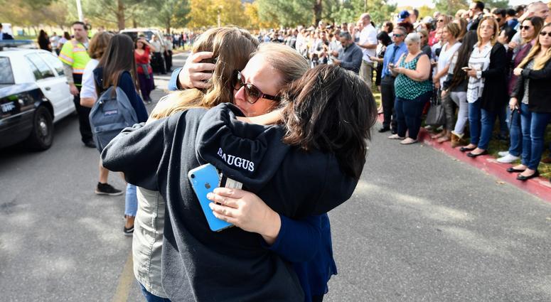 A parent is reunited with her children after a student was killed and other injured during a shooting at Saugus High School in Santa Clarita, Calif. on Nov. 14, 2019. Southern California Shooting