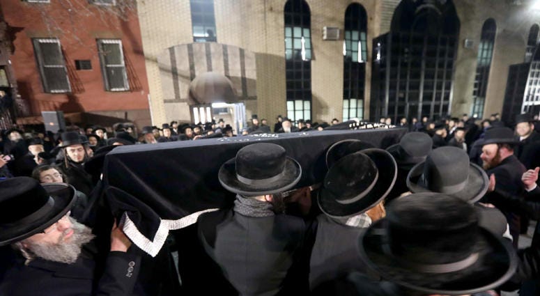 Men carry the casket of Mindel Ferencz through the streets of Williamsburg, Brooklyn Wednesday. Jersey City Victim's Funeral