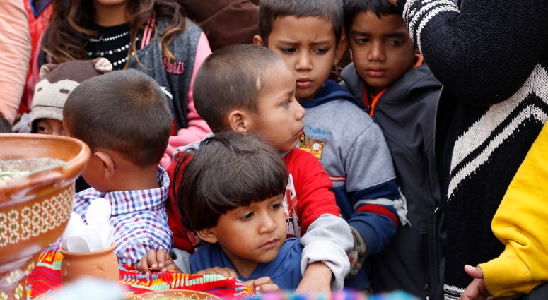 Children wait in line for a plate of food in Tijuana, Baja California, Mexico. Migrant children