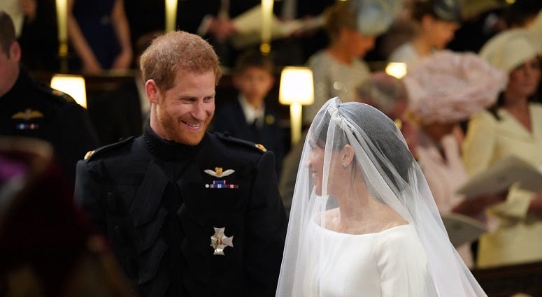 Prince Harry looks at his bride, Meghan Markle, as she arrives accompanied by the Prince of Wales in St George's Chapel at Windsor Castle for their wedding. The Royal Wedding