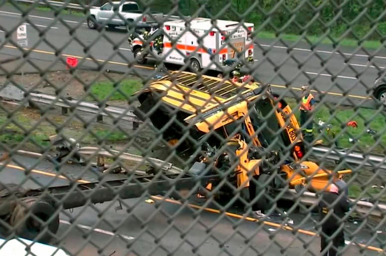 This image taken from WABC-TV video shows an overturned school bus after it collided with a dump truck, injuring multiple people, on Interstate 80 in Mount Olive, N.J., Thursday, May 17, 2018. Deadly New Jersey School Bus Crash