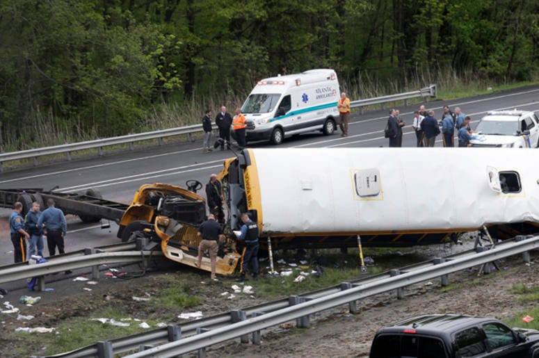 Emergency personnel examine a school bus after it collided with a dump truck, injuring multiple people, on Interstate 80 in Mount Olive, N.J., Thursday, May 17, 2018. Deadly New Jersey School Bus Crash