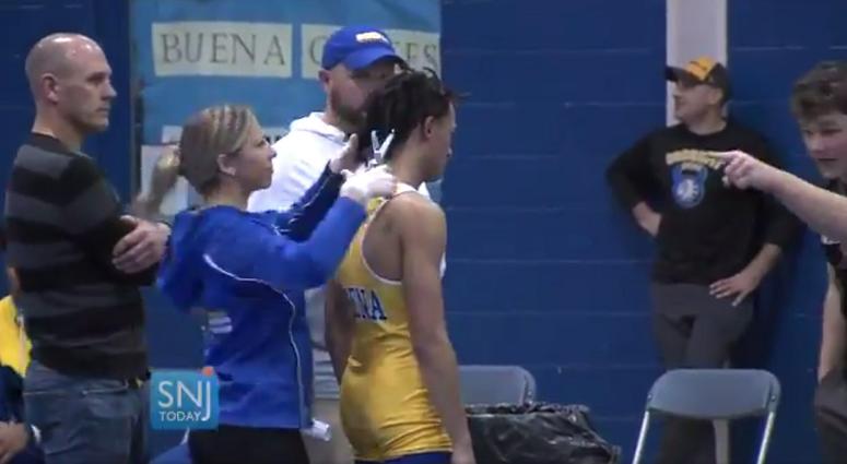 In this image taken from a Wednesday, Dec. 19, 2018 video provided by SNJTODAY.COM, Buena Regional High School wrestler Andrew Johnson gets his hair cut courtside minutes before his match in Buena, N.J. Andrew Johnson during a forced haircut