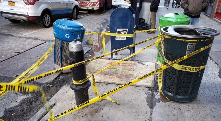 A pit covered by a piece of plywood at the corner of 35th Street and Eighth Avenue in Manhattan, pictured on Oct. 18, 2019. Manhattan Sidewalk Pit