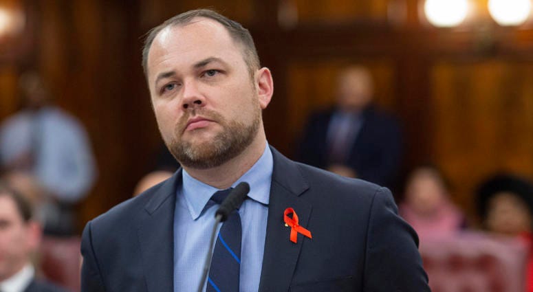 New York City Council Speaker Corey Johnson swears an AIDS awareness ribbon during a City Council meeting Council Speaker Corey Johnson