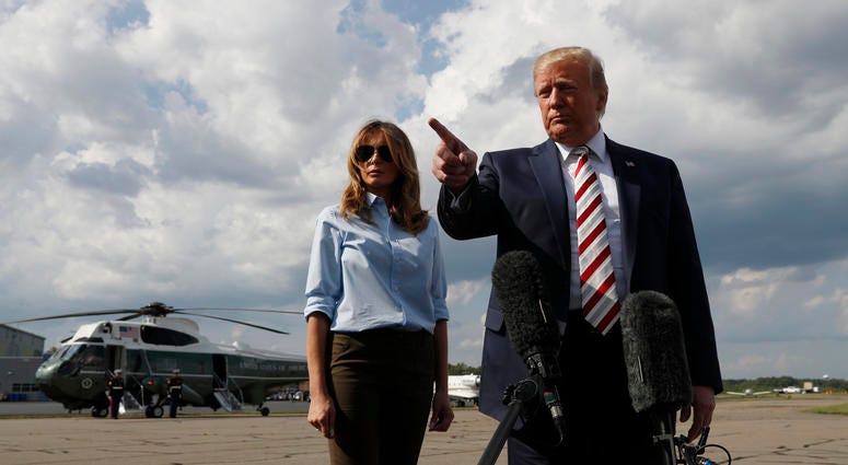 President Donald Trump, with first lady Melania Trump, speaks to the media before boarding Air Force One in Morristown, N.J., Sunday, Aug. 4, 2019. President Trump shootings