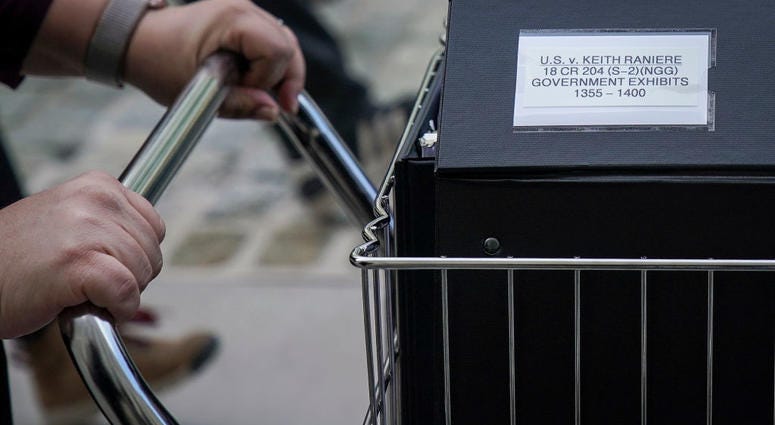 Staff and members of the prosecution team push carts full of court documents related to the U.S. v. Keith Raniere case as they arrive at the U.S. District Court for the Eastern District of New York a, May 7, 2019. U.S. v. Keith Raniere