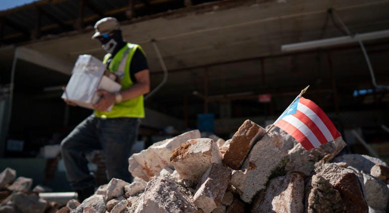 A Puerto Rican flag sits in a pile of rubble after a 6.4 earthquake hit just south of the island on January 7, 2020 in Guánica, Puerto Rico. Puerto Rico Earthquake