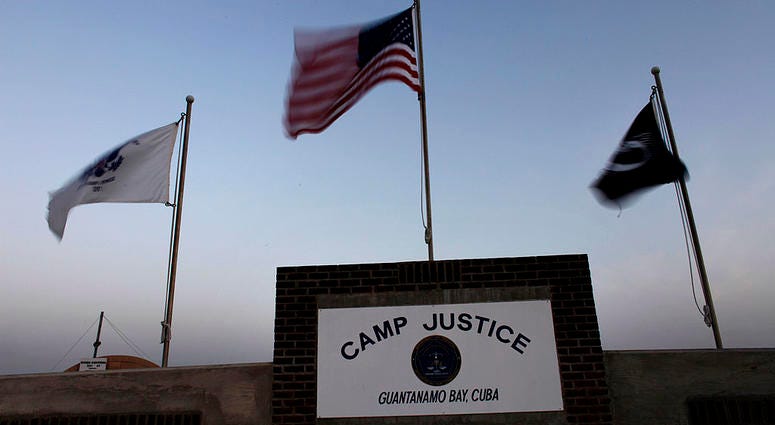 Flags wave above the sign posted at the entrance to Camp Justice, the site of the U.S. war crimes tribunal compound on May 31, 2009 at U.S. Naval Base Guantanamo Bay, Cuba. Guantánamo Bay Camp Justice