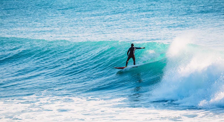 Surfer riding on blue wave. Surfing