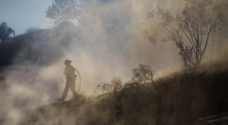 Firefighters put out flareup on a hill in West Hills during the Woolsey Fire in Southern California on November 10, 2018. southern california wildfire