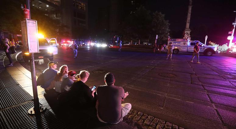 People sit on a curb at Columbus Circle in Manhattan after a power outage left large parts of the West Side of Manhattan without power July 13, 2019. NYC Blackout 2019