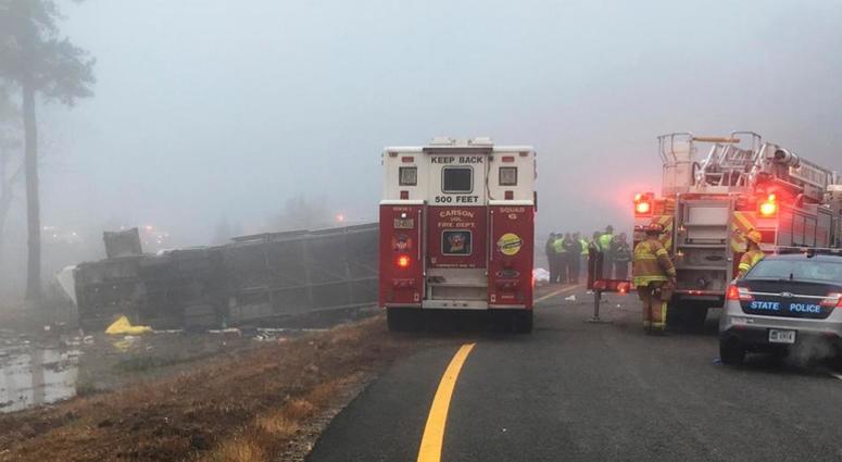 This photo provided by Virginia State Police emergency responders at the scene after a charter bus overturned on an Interstate 95 exit near Kingwood, Va., Tuesday, March 19, 2019. Charter Bus Crash Virginia