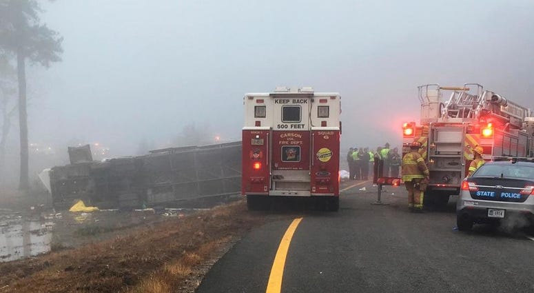 This photo provided by Virginia State Police emergency responders at the scene after a charter bus overturned on an Interstate 95 exit near Kingwood, Va., Tuesday, March 19, 2019. Charter Bus Crash Virginia