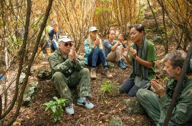 Paul Simon, left, joins in a prayer lead by Aimee Sato
