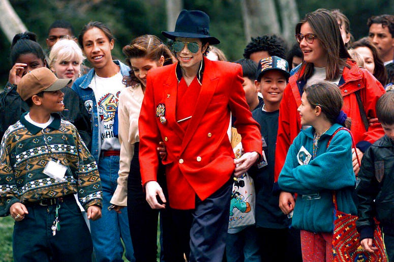 Michael Jackson and Lisa Marie Presley, behind him at left, walk with children that were invited guests at his Neverland Ranch