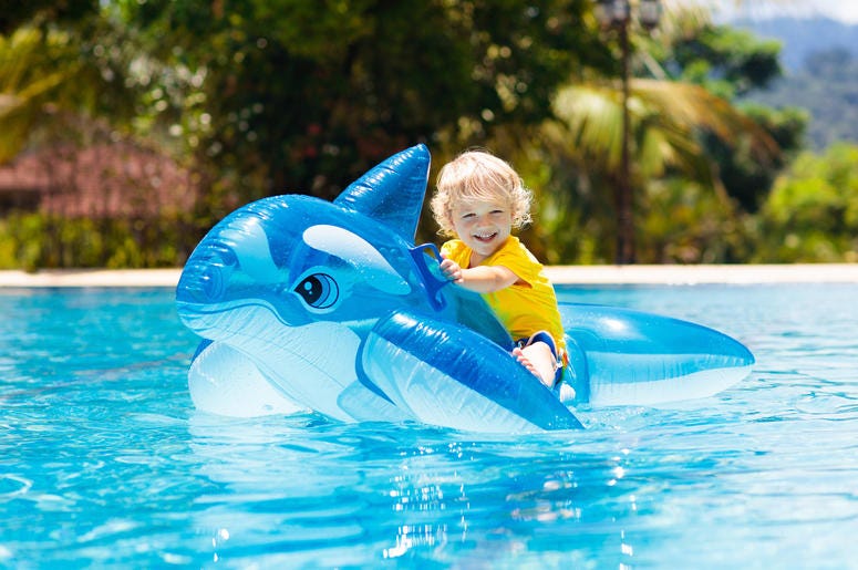 Toddler on shark toy in pool