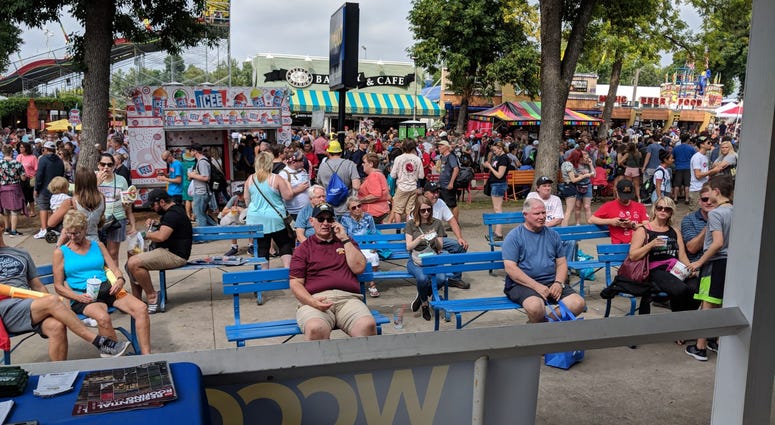 Fair-goers take a break in front of the WCCO Radio Booth at the State Fair
