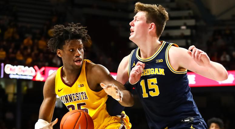 John Teske tries to stop Daniel Oturu Gopher center Daniel Oturu and Michigan center John Teske