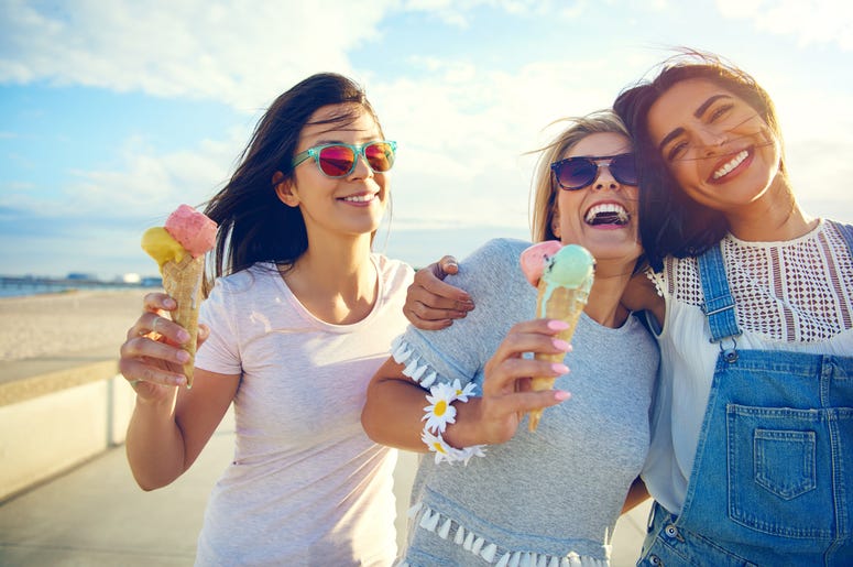Laughing teenage girls eating ice cream cones Laughing teenage girls eating ice cream cones