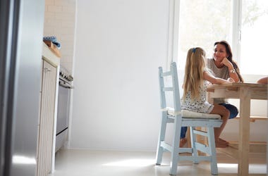 Mom talking to her daughter at a kitchen table