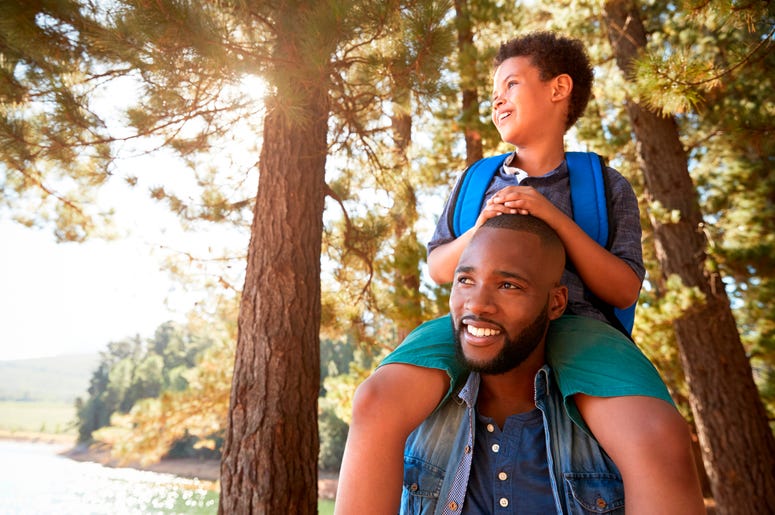 Father Walking In Woods Carrying Son Father Walking In Woods Carrying Son